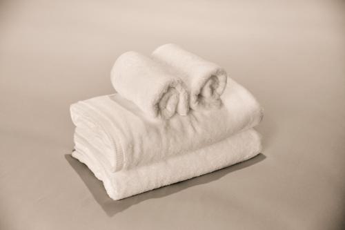una pila de toallas blancas sentadas en una mesa en LiveGRACE Mabuji Park Hotel - Vacation STAY 51973v, en Tokio