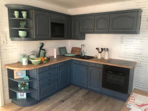 a kitchen with blue cabinets and a counter top at Kinofeeling im Reihenhaus mit schönem Garten in Schwarzenfeld
