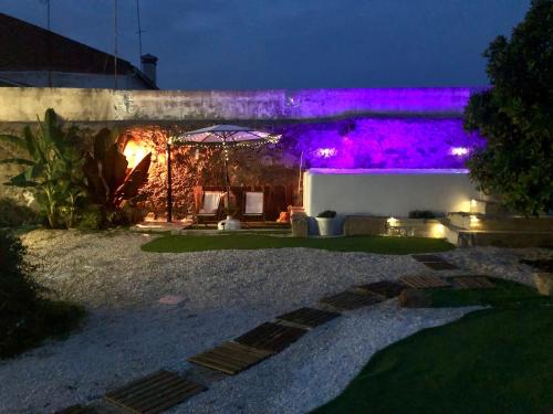 a house with purple lights on the side of it at Pool oasis with private parking -Vigia 8 in Torres Vedras