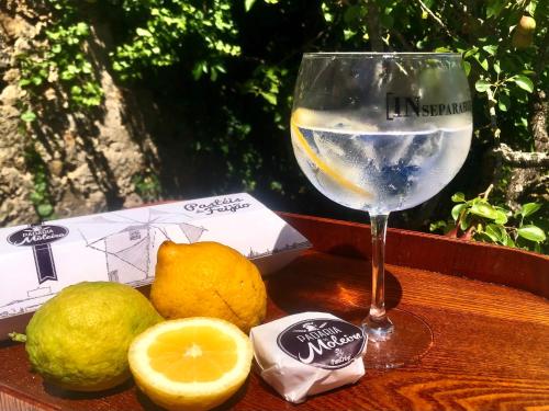 a glass of wine and some lemons on a table at Pool oasis with private parking -Vigia 8 in Torres Vedras