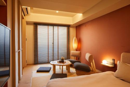 東京にあるLiveGRACE Mabuji Park Hotel - Vacation STAY 51965vのベッド、テーブル、窓が備わる客室です。
