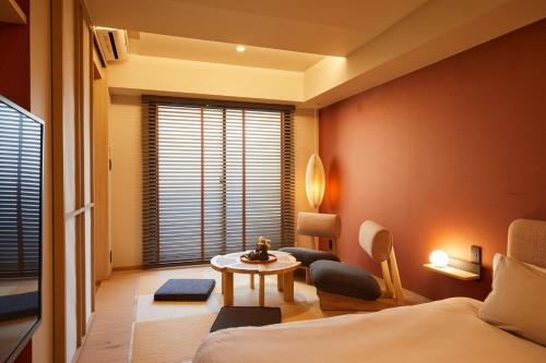a room with a bed and a table and a window at LiveGRACE Mabuji Park Hotel - Vacation STAY 51965v in Tokyo