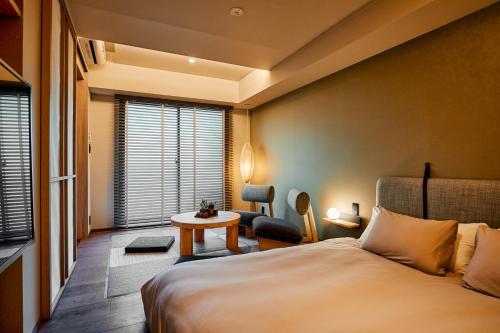東京にあるLiveGRACE Mabuji Park Hotel - Vacation STAY 51799vのベッドとテーブルが備わるホテルルームです。