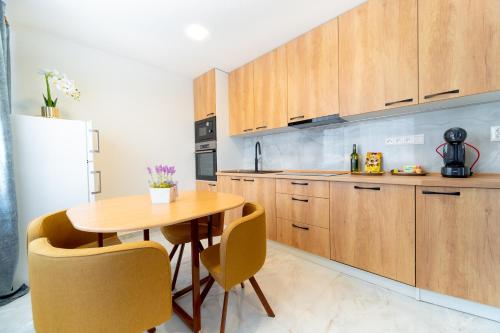 a kitchen with wooden cabinets and a wooden table and chairs at Apartmán Discreet in Kysucké Nové Mesto