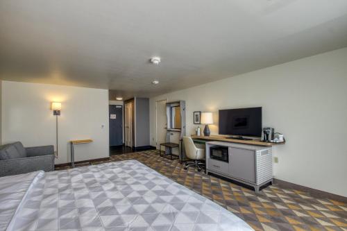 a hotel room with a bed and a living room at Holiday Inn - Appleton by IHG in Appleton