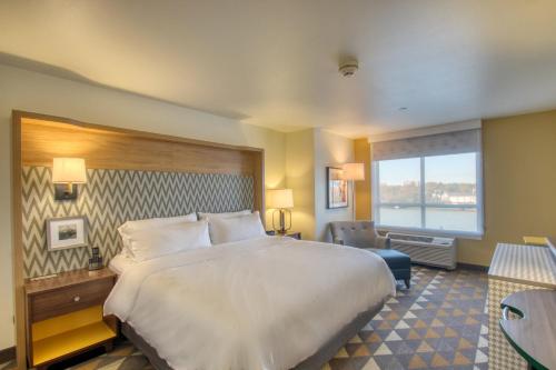 um quarto de hotel com uma cama grande e uma janela em Holiday Inn - Appleton, an IHG Hotel em Appleton