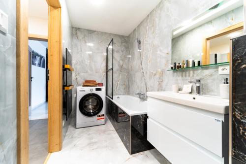 a bathroom with a washing machine and a washer and dryer at Apartmán Discreet in Kysucké Nové Mesto