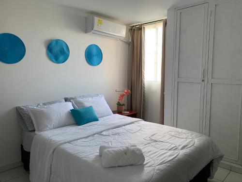 a bedroom with a bed with blue plates on the wall at Habitación en apartamento compartido al frente del cc Unico in Barranquilla