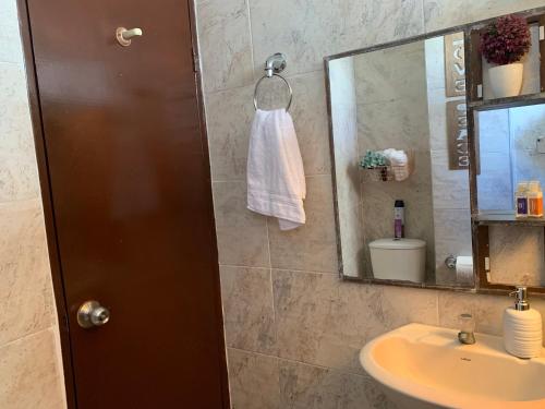 een badkamer met een wastafel en een spiegel bij Habitación en apartamento compartido al frente del cc Unico in Barranquilla
