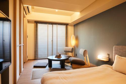 1 dormitorio con cama, mesa y TV en LiveGRACE Mabuji Park Hotel - Vacation STAY 51943v en Tokio