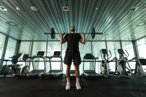 a man lifting a bar in a gym at Crowne Plaza Belgrade by IHG in Belgrade