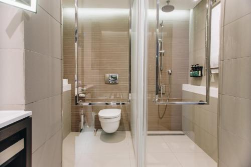 a bathroom with a shower with a toilet and a sink at Crowne Plaza Belgrade by IHG in Belgrade