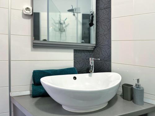 a bathroom with a white sink and a mirror at Hétvezér Penthouse Apartments in Szeged