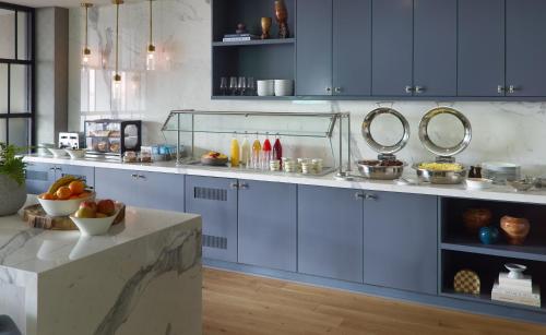 a kitchen with blue cabinets and a bowl of fruit on a counter at Marriott Knoxville Downtown in Knoxville