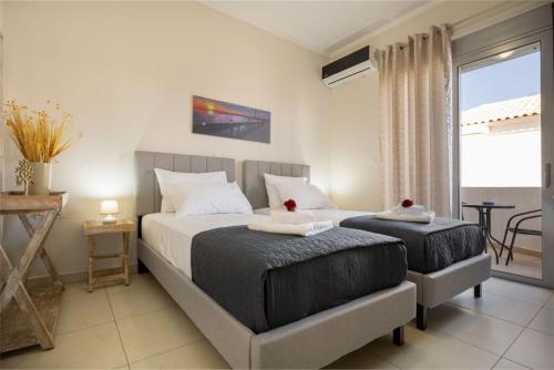 a bedroom with two beds and a balcony at Christini Cozy Apartment in Souda