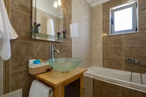 a bathroom with a bowl sink and a bath tub at Christini Cozy Apartment in Souda