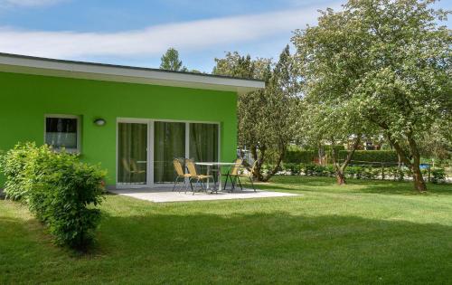 una casa verde con tavolo e sedie nel cortile di Bungis Am Grimnitzsee a Joachimsthal