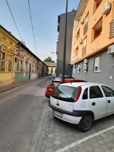 a white car parked on the side of a street at Nikola NS in Novi Sad