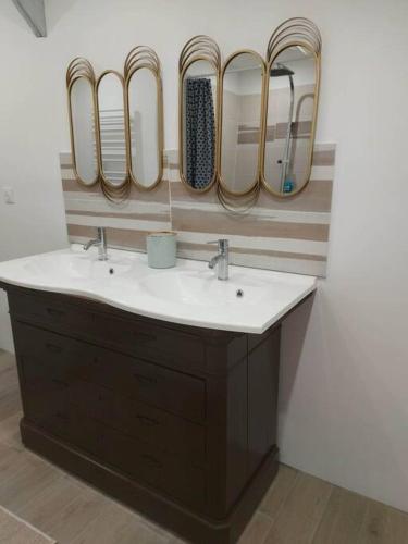 La salle de bains est pourvue d'un lavabo et de 4 miroirs. dans l'établissement LA MAISON D'AUXANNE, à Giffaumont