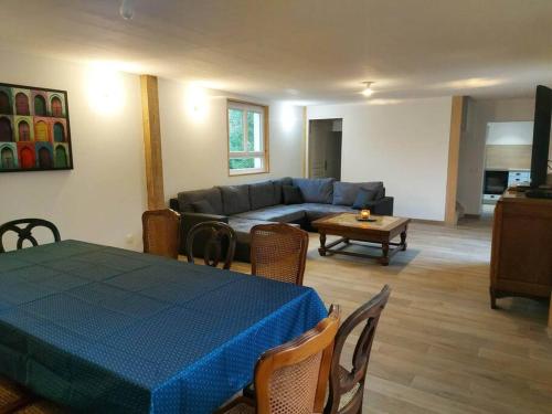 sala de estar con mesa azul y sofá en LA MAISON D'AUXANNE, en Giffaumont-Champaubert