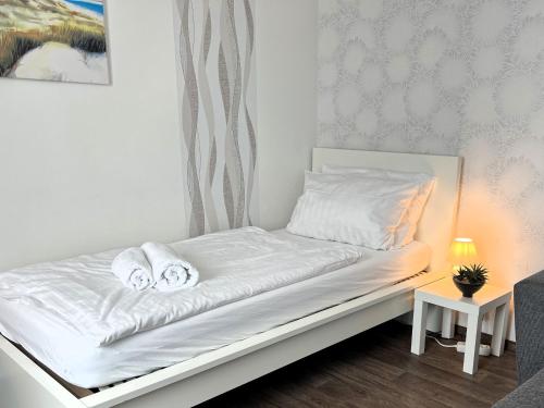 a white bed with towels on it in a room at Ferienwohnungen an der Weser in Bremerhaven