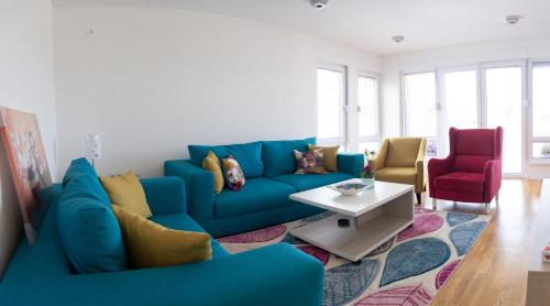 a living room with a blue couch and a table at Countryside Resort Sarajevo in Hadžići