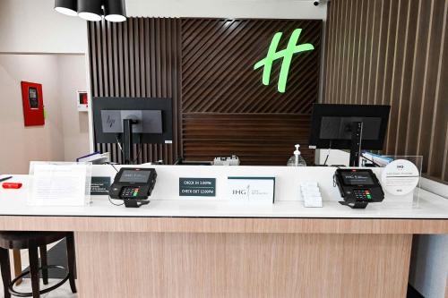 a reception counter in a hospital with two phones at Holiday Inn Toledo - Maumee I-80/90 by IHG in Maumee
