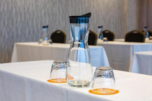a vase sitting on a table with two glasses at Holiday Inn Toledo - Maumee I-80/90 by IHG in Maumee
