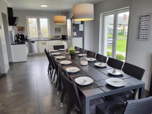 a dining room with a long table and chairs at Villa Bella Sauna & Jacuzzi in Międzywodzie