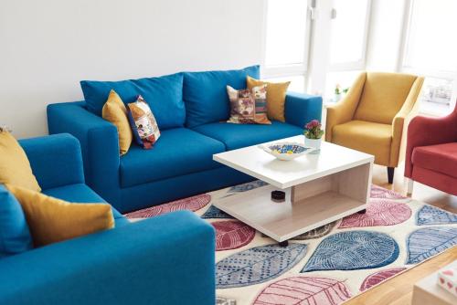 a blue couch in a living room with a table at Countryside Resort Sarajevo in Hadžići
