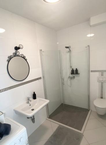 a white bathroom with a shower and a sink at Tijara Apartment in Rijeka