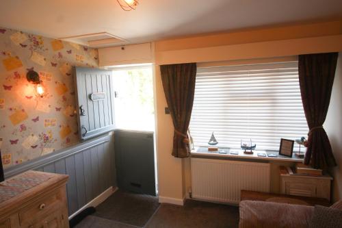 una camera con una grande finestra e una finestra argentata di Briar Cottage a Looe