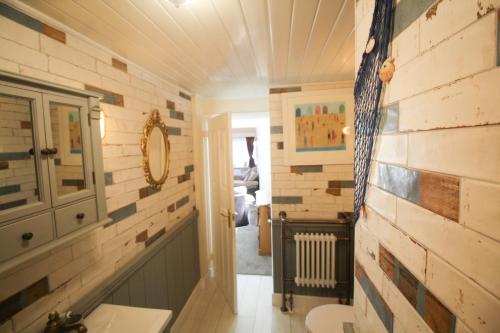 a bathroom with wooden walls and a sink at Briar Cottage in Looe