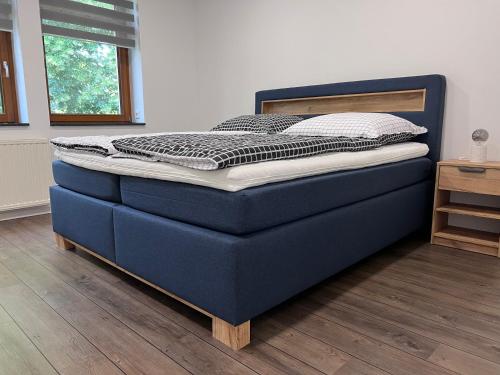 niebieskie łóżko w pokoju z drewnianą podłogą w obiekcie Zentrale Ferienwohnung w mieście Eisenach