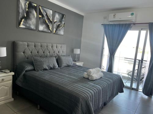 a bedroom with a bed with a blue comforter at Departamento de Categoria Torre Costanera Norte, Corrientes in Corrientes