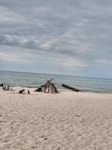 a group of people laying on a beach at Morelowe Domki in Mielenko
