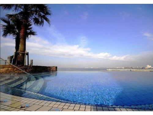 una gran piscina con palmeras y agua en Hotel Sunlife Garden - Vacation STAY 55411v, en Hiratsuka