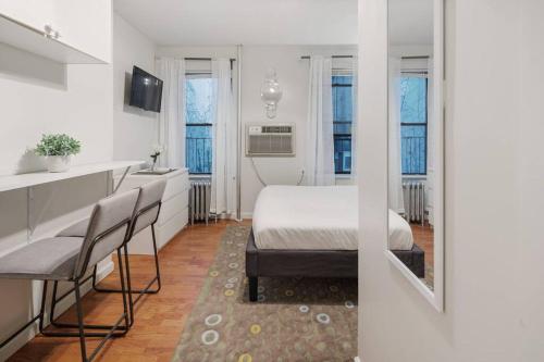 een slaapkamer met een bed en een keuken met ramen bij Elevate Apartment at Times Square - Cozy Studio in Times Square and Nearby Restaurants in New York