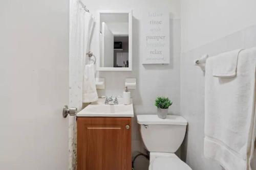 een badkamer met een toilet, een wastafel en een spiegel bij Elevate Apartment at Times Square - Cozy Studio in Times Square and Nearby Restaurants in New York