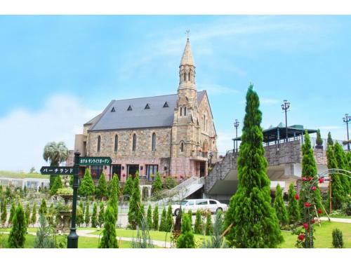 a large church with a tower and a bunch of trees at Hotel Sunlife Garden - Vacation STAY 55407v in Hiratsuka