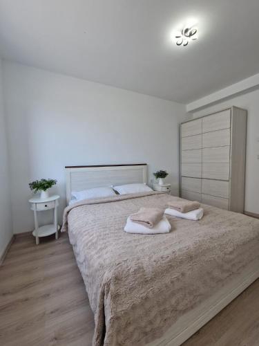 a bedroom with a large bed with two pillows on it at San Casa Apartment in Sebeş