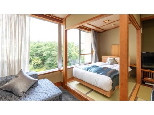 - une chambre avec un lit et une grande fenêtre dans l'établissement Tsukioka Onsen Furinya - Vacation STAY 55981v, à Shibata