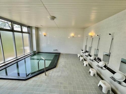 La salle de bains est pourvue d'une piscine, de lavabos et de miroirs. dans l'établissement ISOLA Izu Kogen - Vacation STAY 55831v, à Itō