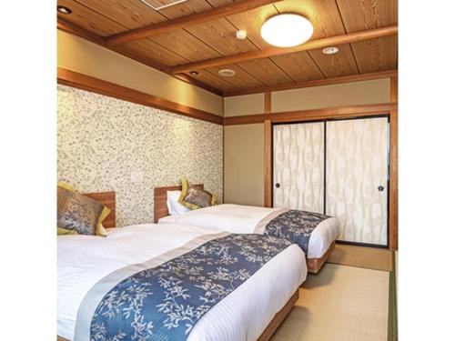 two beds in a room with a window at Tsukioka Onsen Furinya - Vacation STAY 55991v in Shibata