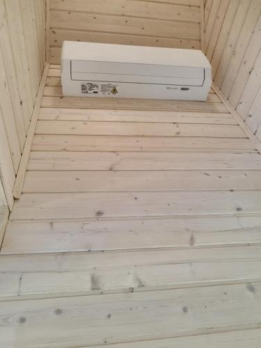 a heater sitting on a wooden floor in a sauna at Morelowe Domki in Mielenko