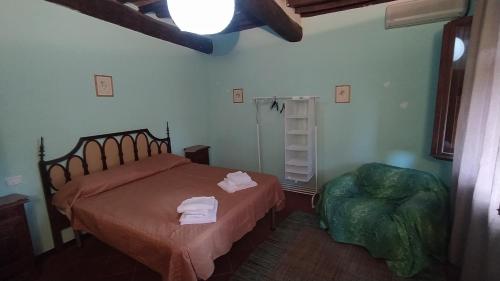 ein Schlafzimmer mit einem Bett und einem Stuhl in der Unterkunft CASA MANSI ROOMS AND HOSPITALITY in Lucca