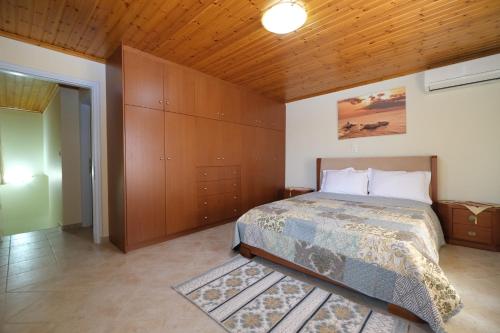 a bedroom with a bed and a wooden ceiling at Anemoessa Mesonet in Romanón
