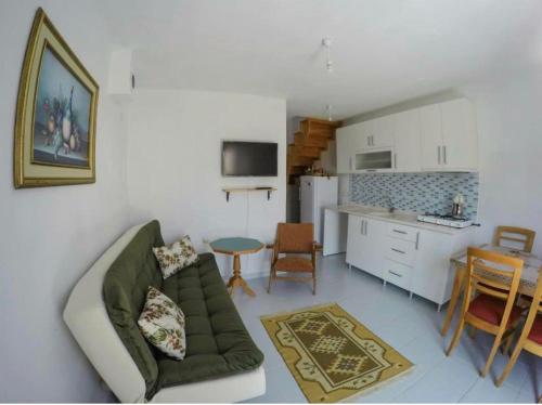 ein Wohnzimmer mit einem Sofa und einer Küche in der Unterkunft Sirinevler Apart IMROS in Gokceada Town
