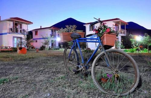 Una bicicleta azul estacionada frente a una casa en Sirinevler Apart IMROS, en Gokceada Town