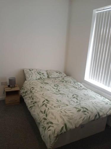 Bett in einem Zimmer mit einem Fenster und einem Bett sidx sidx sidx sidx in der Unterkunft Ensuite Double-bed H3 close to Burnley city centre in Burnley